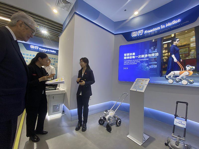 Picture 5: Dr. Tej Bunnag (left) observes a guide robot designed for persons with visual impairments