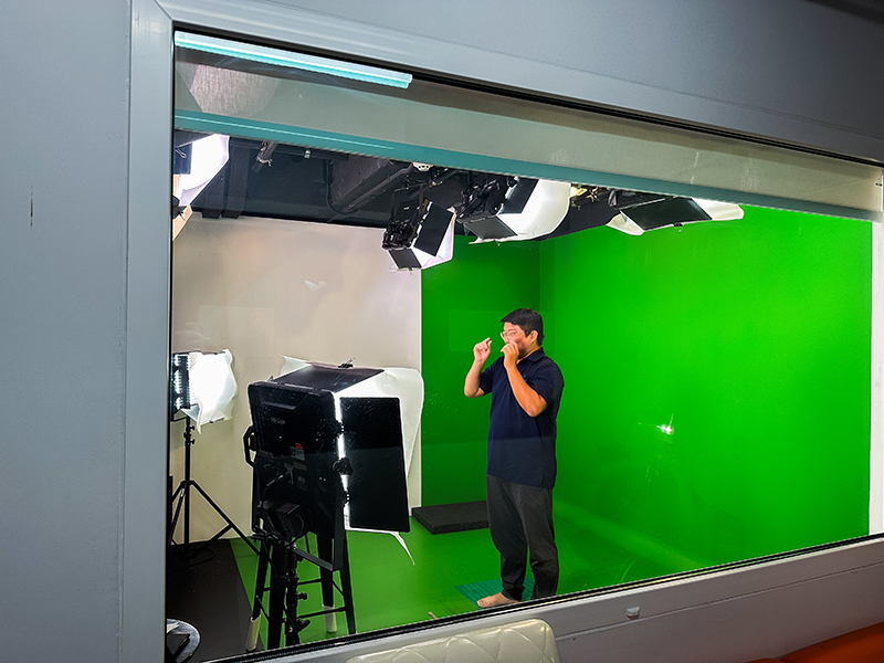 Picture 6: The sign language interpreter signs in front of the camera during a video recording.