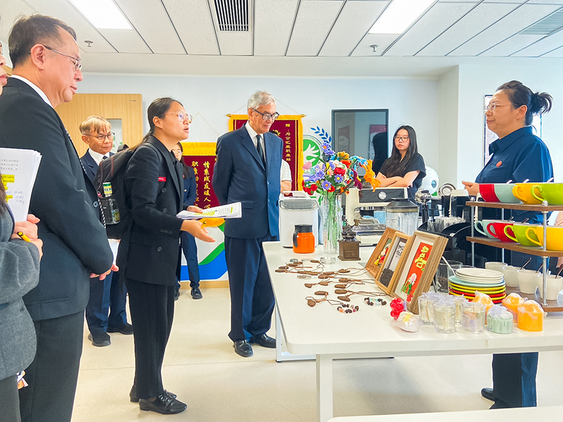 Picture 8: Dr. Tej Bunnag (center), Mr. Piroon Laismit (left), and Mr. Somchai Rungsilp (left, in the background) observe products made by persons with disabilities