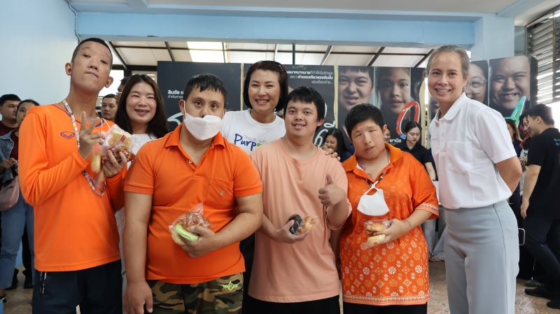 Representatives from three hotels and persons with intellectual disabilities pose for a photo together after the freshly baked bread donation.