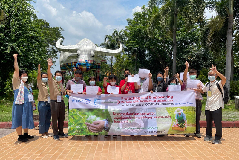 Participants holding their certificates and APCD staff posing with Doo-Doo, the Museum mascot, in a group photo.