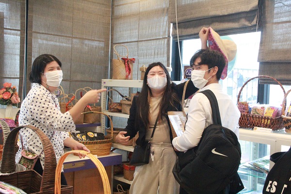 Visitors choosing product made by persons with disabilities by disability-friendly businesses at the APCD's 60+ Plus Bakery, Chocolate Café, during a guided tour.