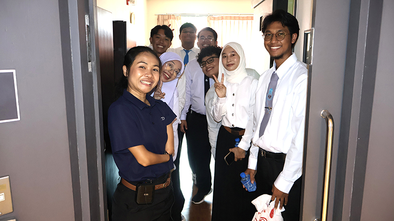Photo 5: Ms. Siriporn guided the students on a tour of APCD’s training facilities, highlighting its accessible accommodation and the universal design features of training building. The students also took a group photo together in front of the accessible sliding door of the accommodation room.
