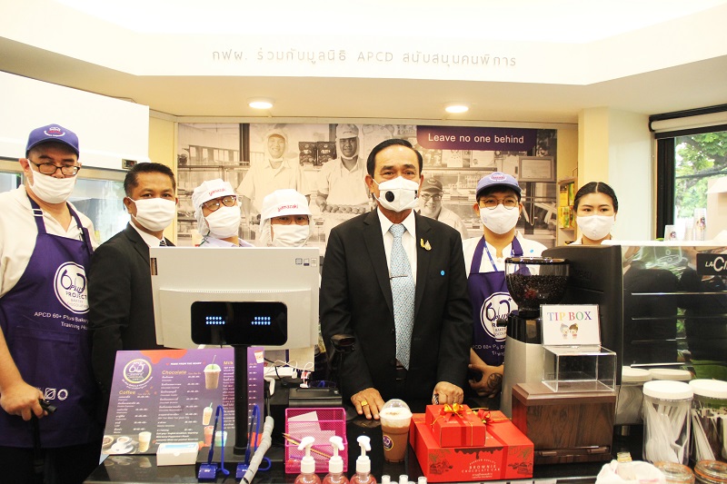 Group Photo of the Prime Minister with cafe staff with disabilities inside the cafe. 