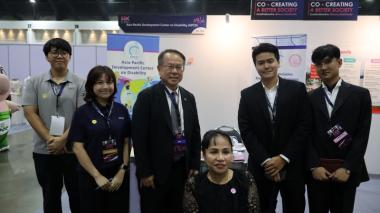 Mr. Piroon Laismit and participants pose for a photo at the APCD booth.